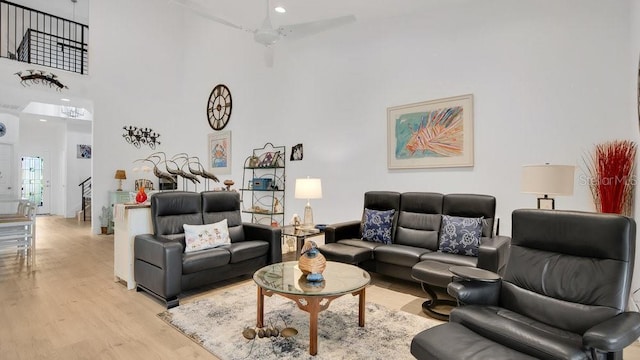 302 Tammie Sue Ln, Deland, FL 32724 - living area featuring light wood-style flooring, a towering ceiling, stairway, and ceiling fan