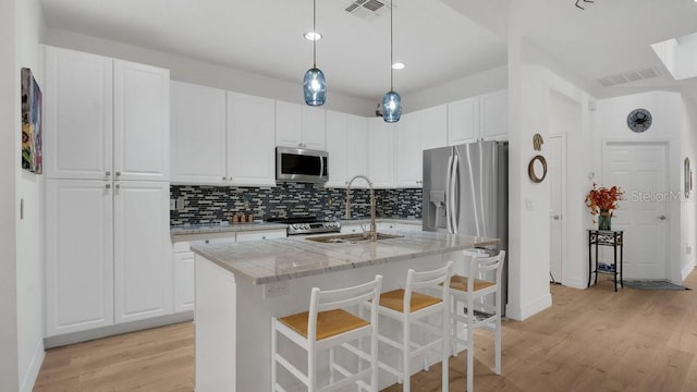 302 Tammie Sue Ln, Deland, FL 32724 - kitchen with stainless steel appliances, light wood-style flooring, white cabinets, decorative backsplash, and recessed lighting