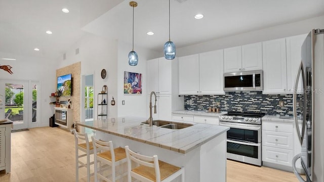 302 Tammie Sue Ln, Deland, FL 32724 - kitchen with appliances with stainless steel finishes, a sink, decorative backsplash, white cabinetry, and high vaulted ceiling