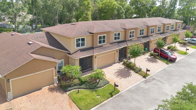 302 Tammie Sue Ln, Deland, FL 32724 - view of front of home with stucco siding, an attached garage, driveway, and roof with shingles