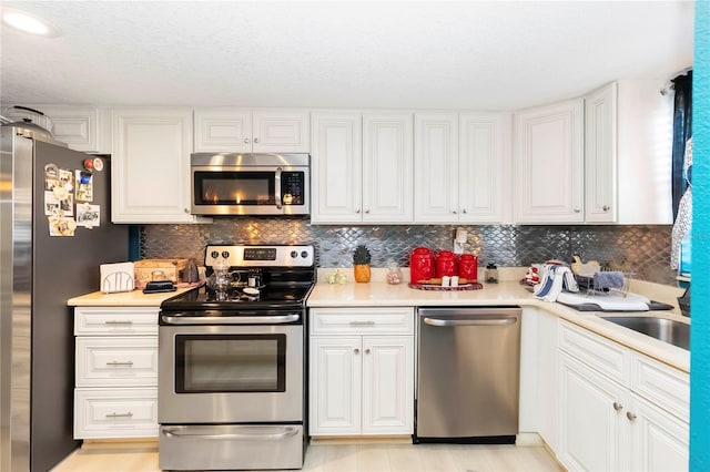 625 N Halifax Ave Unit 11, Daytona Beach, FL 32118 - kitchen with stainless steel appliances, light countertops, white cabinetry, and backsplash