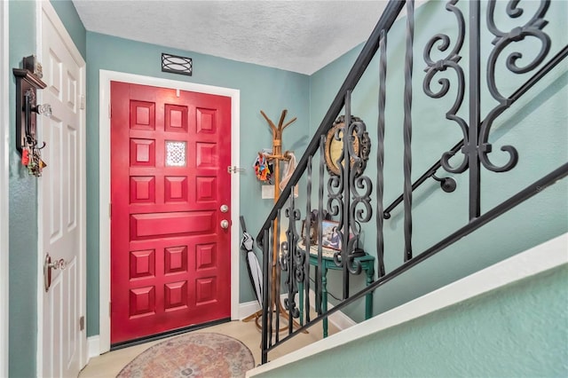 625 N Halifax Ave Unit 11, Daytona Beach, FL 32118 - entryway featuring baseboards, a textured ceiling, and stairs
