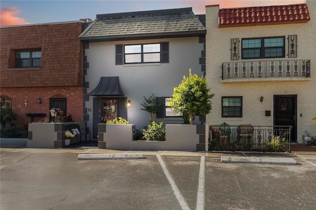 625 N Halifax Ave Unit 11, Daytona Beach, FL 32118 - view of front of property featuring uncovered parking, stucco siding, and mansard roof