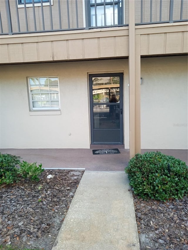 1640 Juno Trl Unit 103F, Astor, FL 32102 - property entrance with a balcony and stucco siding