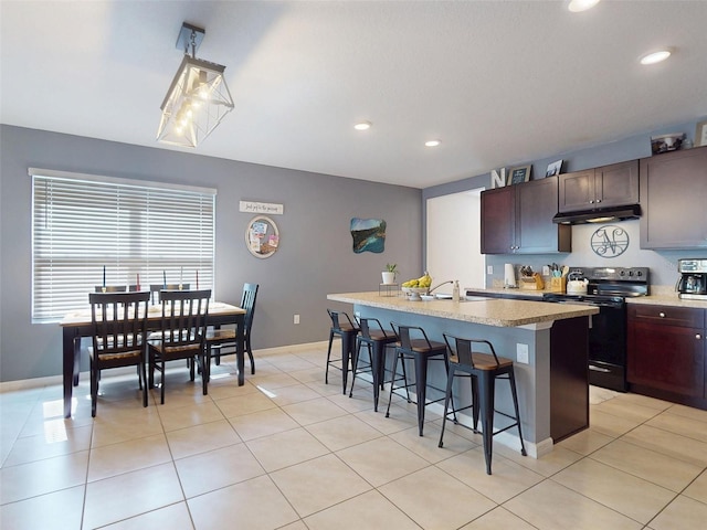 2919 Sime St, New Smyrna Beach, FL 32168 - kitchen with black range with electric stovetop, under cabinet range hood, a kitchen breakfast bar, a center island with sink, and recessed lighting