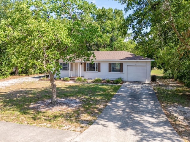 31 Lake Dr, Debary, FL 32713 - view of front of property with an attached garage, driveway, central air condition unit, and roof with shingles