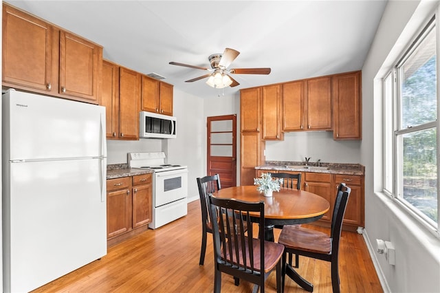 31 Lake Dr, Debary, FL 32713 - kitchen with white appliances, light wood-style floors, ceiling fan, and brown cabinets