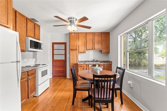 31 Lake Dr, Debary, FL 32713 - kitchen with white appliances, light wood-style flooring, brown cabinets, and a ceiling fan
