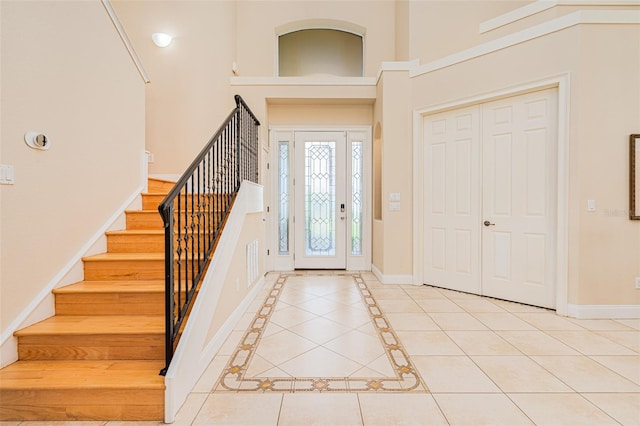 4427 S Atlantic Ave, Port Orange, FL 32127 - entryway with light tile patterned floors, baseboards, stairs, and a towering ceiling