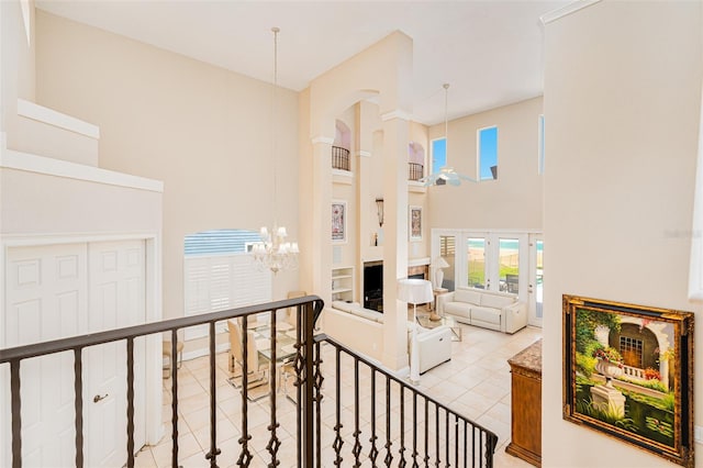 4427 S Atlantic Ave, Port Orange, FL 32127 - stairway featuring a towering ceiling, a chandelier, tile patterned flooring, plenty of natural light, and arched walkways