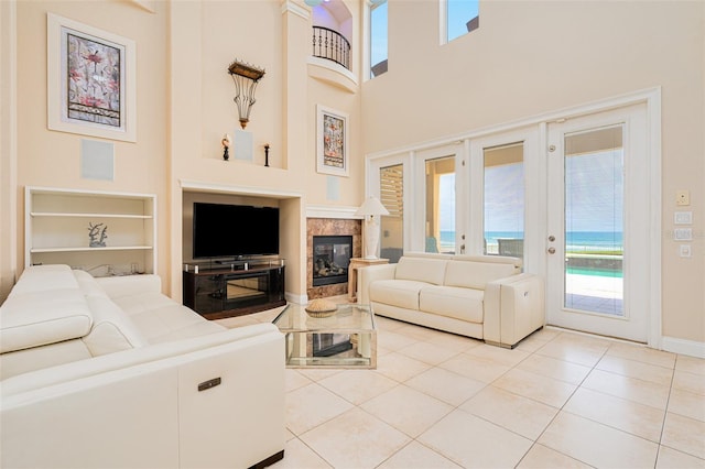 4427 S Atlantic Ave, Port Orange, FL 32127 - living area featuring built in shelves, a towering ceiling, light tile patterned flooring, baseboards, and a high end fireplace