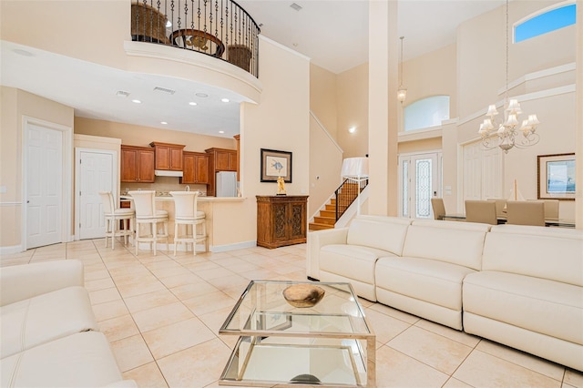 4427 S Atlantic Ave, Port Orange, FL 32127 - living room featuring a high ceiling, light tile patterned floors, baseboards, stairway, and a chandelier