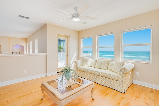 4427 S Atlantic Ave, Port Orange, FL 32127 - living area with wood finished floors, a ceiling fan, baseboards, and a water view