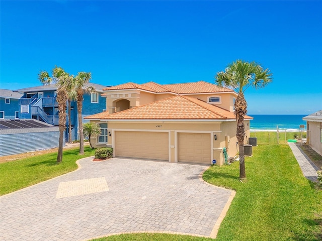 4427 S Atlantic Ave, Port Orange, FL 32127 - view of front of house featuring a garage, a front yard, decorative driveway, stucco siding, and a water view