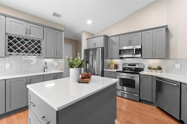 1637 Bent Oaks Blvd, Deland, FL 32724 - kitchen featuring stainless steel appliances, gray cabinetry, backsplash, light countertops, and light wood-style floors