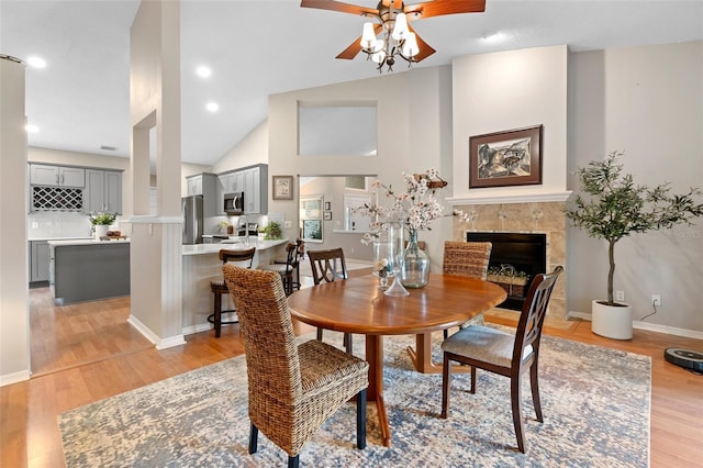 1637 Bent Oaks Blvd, Deland, FL 32724 - dining space featuring a ceiling fan, a high end fireplace, light wood finished floors, high vaulted ceiling, and baseboards