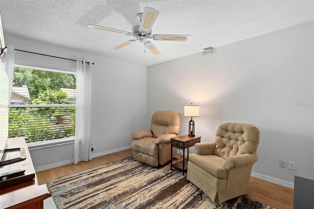 1637 Bent Oaks Blvd, Deland, FL 32724 - living area featuring wood finished floors, a textured ceiling, ceiling fan, and baseboards