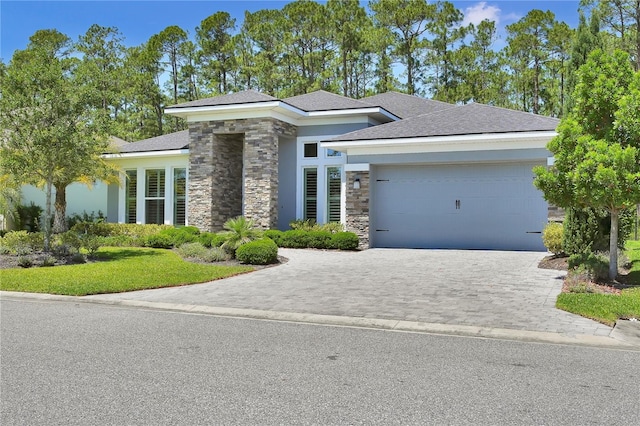 344 Stirling Bridge Dr, Ormond Beach, FL 32174 - prairie-style house with stone siding, an attached garage, decorative driveway, stucco siding, and a shingled roof