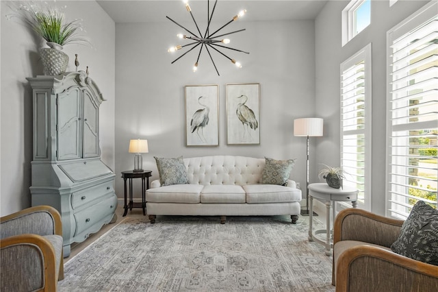 344 Stirling Bridge Dr, Ormond Beach, FL 32174 - living room featuring a chandelier, baseboards, a towering ceiling, and light wood-style flooring