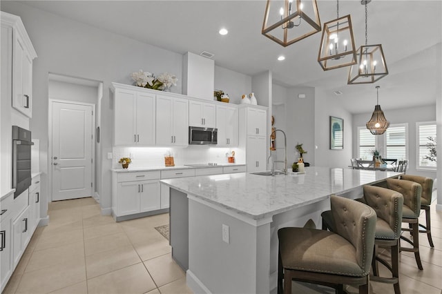 344 Stirling Bridge Dr, Ormond Beach, FL 32174 - kitchen featuring appliances with stainless steel finishes, a sink, a chandelier, white cabinets, and a center island with sink