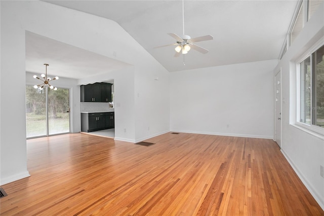 2215 Lake Ruby Rd, Deland, FL 32724 - unfurnished living room featuring a chandelier, vaulted ceiling, a ceiling fan, light wood finished floors, and baseboards