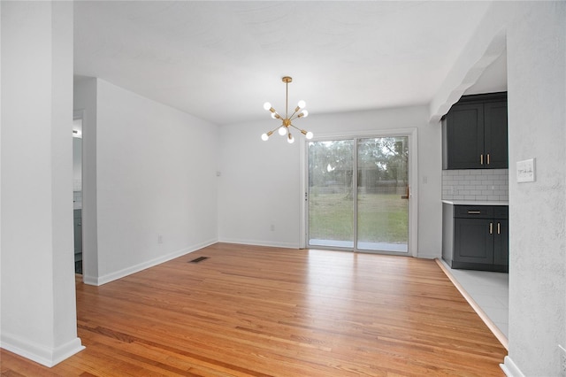 2215 Lake Ruby Rd, Deland, FL 32724 - unfurnished dining area featuring light wood-style floors, a chandelier, and baseboards