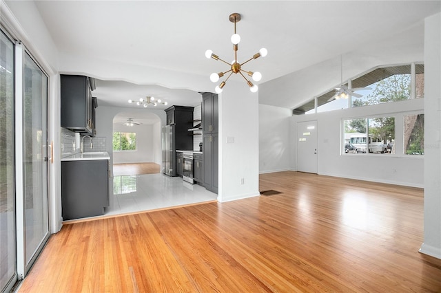 2215 Lake Ruby Rd, Deland, FL 32724 - unfurnished living room with ceiling fan, a chandelier, healthy amount of natural light, light wood-style flooring, and vaulted ceiling