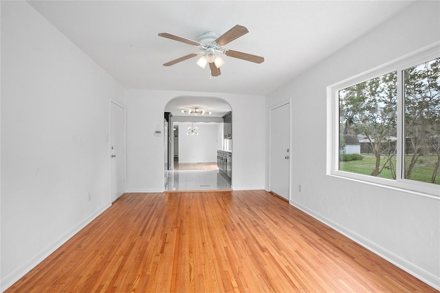 2215 Lake Ruby Rd, Deland, FL 32724 - empty room featuring arched walkways, ceiling fan, light wood finished floors, and baseboards