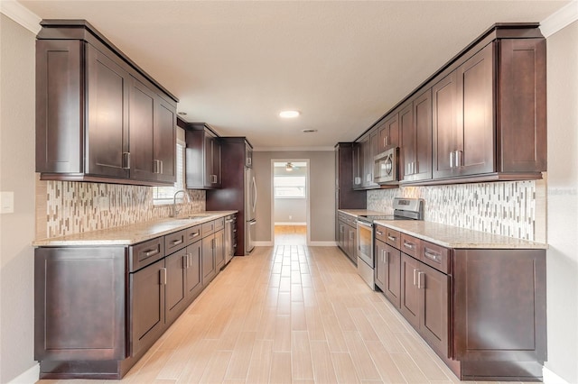 1032 Bel Aire Dr, Daytona Beach, FL 32118 - kitchen featuring stainless steel appliances, a sink, dark brown cabinetry, ornamental molding, and recessed lighting