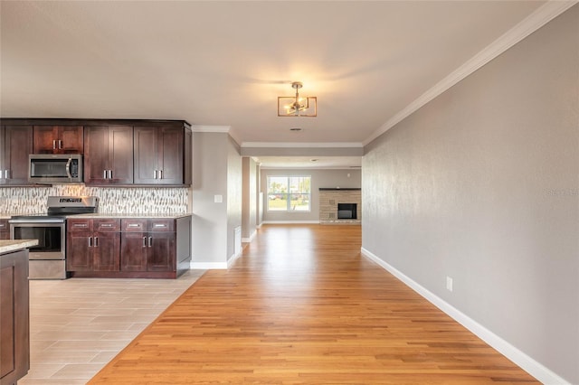 1032 Bel Aire Dr, Daytona Beach, FL 32118 - kitchen with stainless steel appliances, decorative backsplash, dark brown cabinets, light countertops, and light wood-type flooring