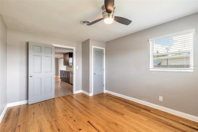 1032 Bel Aire Dr, Daytona Beach, FL 32118 - unfurnished bedroom featuring baseboards, light wood-type flooring, ceiling fan, and a closet
