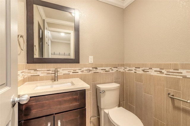 1032 Bel Aire Dr, Daytona Beach, FL 32118 - half bath with ornamental molding, tile walls, toilet, vanity, and a wainscoted wall