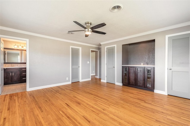 1032 Bel Aire Dr, Daytona Beach, FL 32118 - unfurnished bedroom featuring two closets, ornamental molding, light wood-type flooring, baseboards, and ensuite bathroom