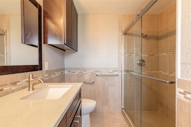 1032 Bel Aire Dr, Daytona Beach, FL 32118 - full bathroom with tile walls, vanity, toilet, a stall shower, and a textured ceiling