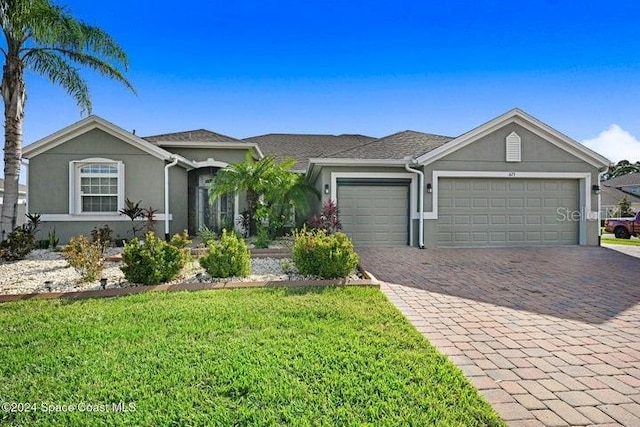 675 Easton Forest Cir SE, Palm Bay, FL 32909 - ranch-style house with an attached garage, stucco siding, decorative driveway, and a front yard