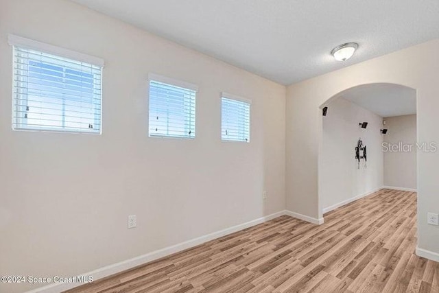 675 Easton Forest Cir SE, Palm Bay, FL 32909 - spare room featuring arched walkways, light wood finished floors, and baseboards
