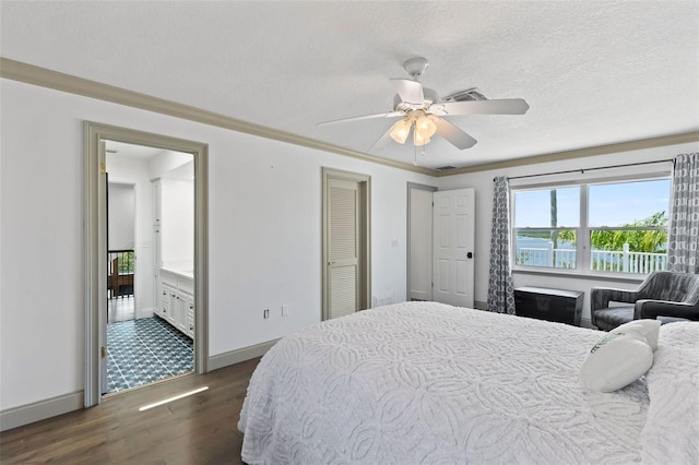 604 Springdale Dr, Flagler Beach, FL 32136 - bedroom with dark wood-style flooring, baseboards, ceiling fan, connected bathroom, and a textured ceiling