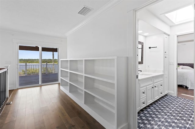 604 Springdale Dr, Flagler Beach, FL 32136 - hallway with a sink, a skylight, crown molding, dark wood-style flooring, and baseboards