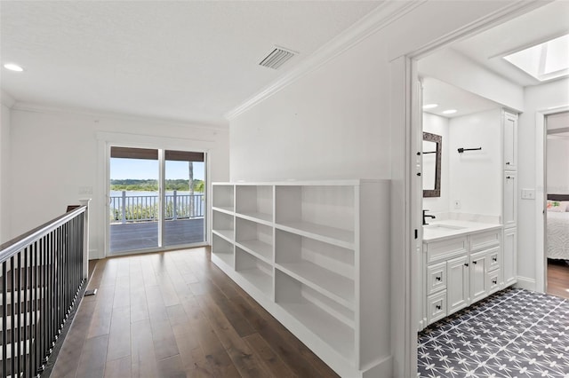 604 Springdale Dr, Flagler Beach, FL 32136 - hall with a sink, dark wood-style floors, crown molding, recessed lighting, and a skylight