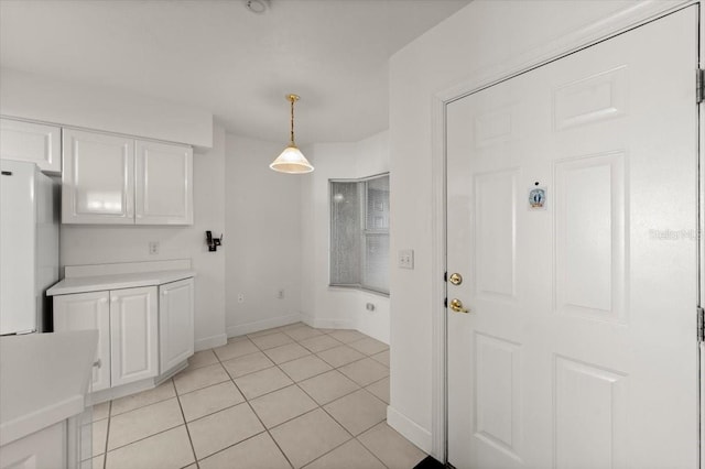 3425 S Atlantic Ave Unit 1602, Daytona Beach, FL 32118 - kitchen with white cabinetry, freestanding refrigerator, light countertops, light tile patterned floors, and baseboards