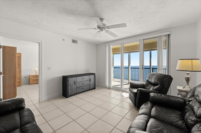 3425 S Atlantic Ave Unit 1602, Daytona Beach, FL 32118 - living room with a water view, a ceiling fan, light tile patterned flooring, and baseboards