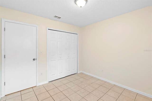 910 Sheeler Oaks Dr, Apopka, FL 32703 - unfurnished bedroom featuring a closet, baseboards, and a textured ceiling