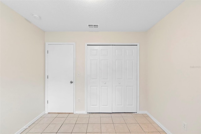 910 Sheeler Oaks Dr, Apopka, FL 32703 - unfurnished bedroom with light tile patterned floors, baseboards, a closet, and a textured ceiling