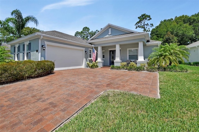 171 Birchmont Dr, Deland, FL 32724 - view of front of house featuring stucco siding, covered porch, an attached garage, a front yard, and driveway