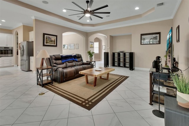 171 Birchmont Dr, Deland, FL 32724 - living area with arched walkways, a ceiling fan, crown molding, a tray ceiling, and light marble finish flooring