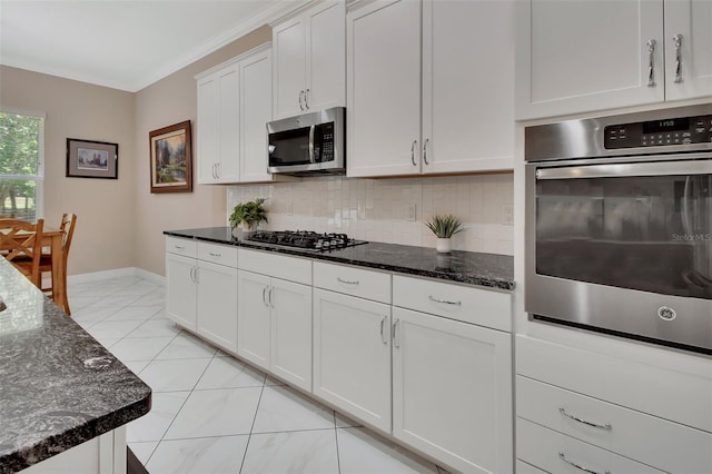 171 Birchmont Dr, Deland, FL 32724 - kitchen featuring appliances with stainless steel finishes, tasteful backsplash, white cabinets, dark stone counters, and baseboards
