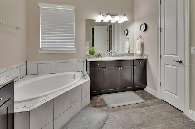 171 Birchmont Dr, Deland, FL 32724 - full bath featuring vanity, a bath, wood finish floors, and baseboards