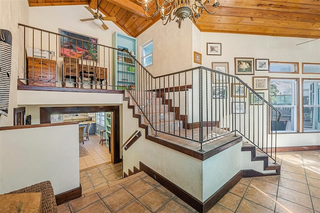 61 E Bayshore Dr, Port Orange, FL 32127 - staircase featuring wooden ceiling with exposed beams, a chandelier, a ceiling fan, high vaulted ceiling, and baseboards