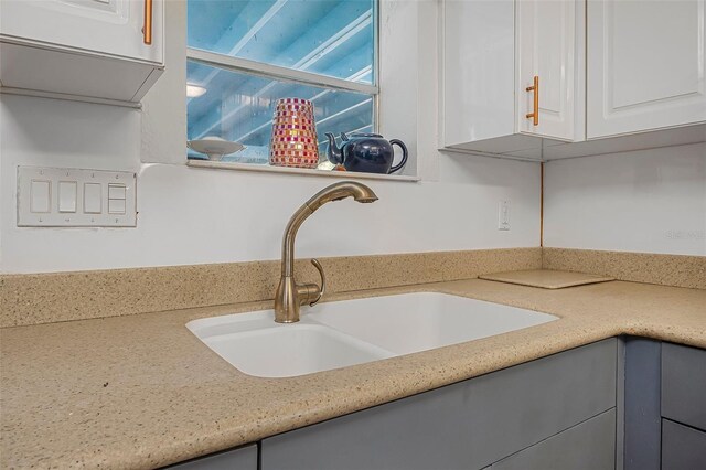 61 E Bayshore Dr, Port Orange, FL 32127 - kitchen view of a sink, gray cabinetry, light countertops, and white cabinets