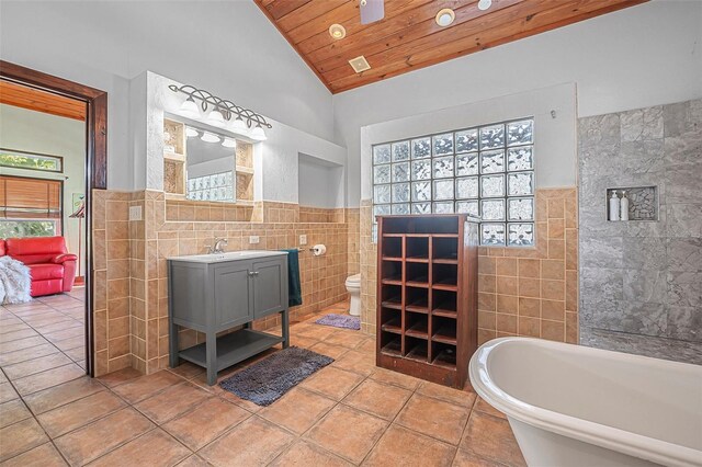 61 E Bayshore Dr, Port Orange, FL 32127 - full bath with tile walls, wood ceiling, toilet, vaulted ceiling, and tile patterned flooring